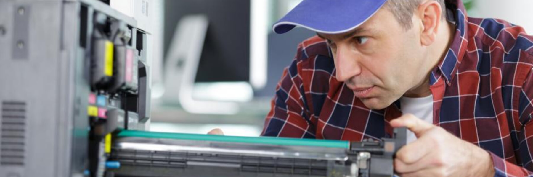 Maintenance man changes printer cartridge in office  