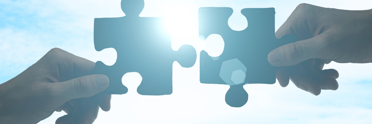 Two people fitting puzzle pieces together