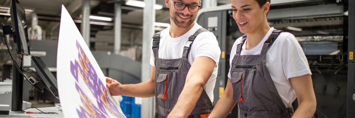 workers smiling over large printed materials