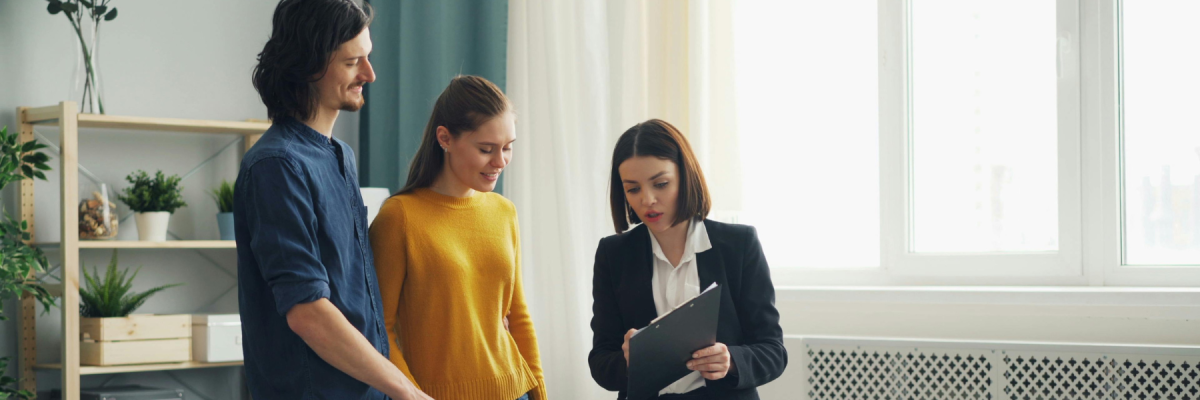 Realtor and couple looking at clipboard