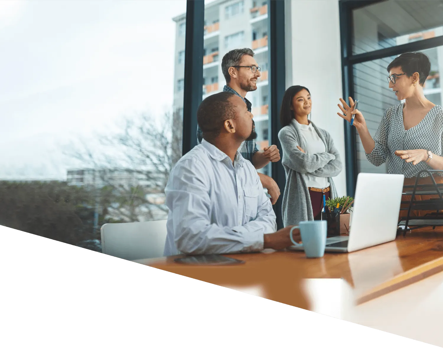 a group of office workers talking around a desk